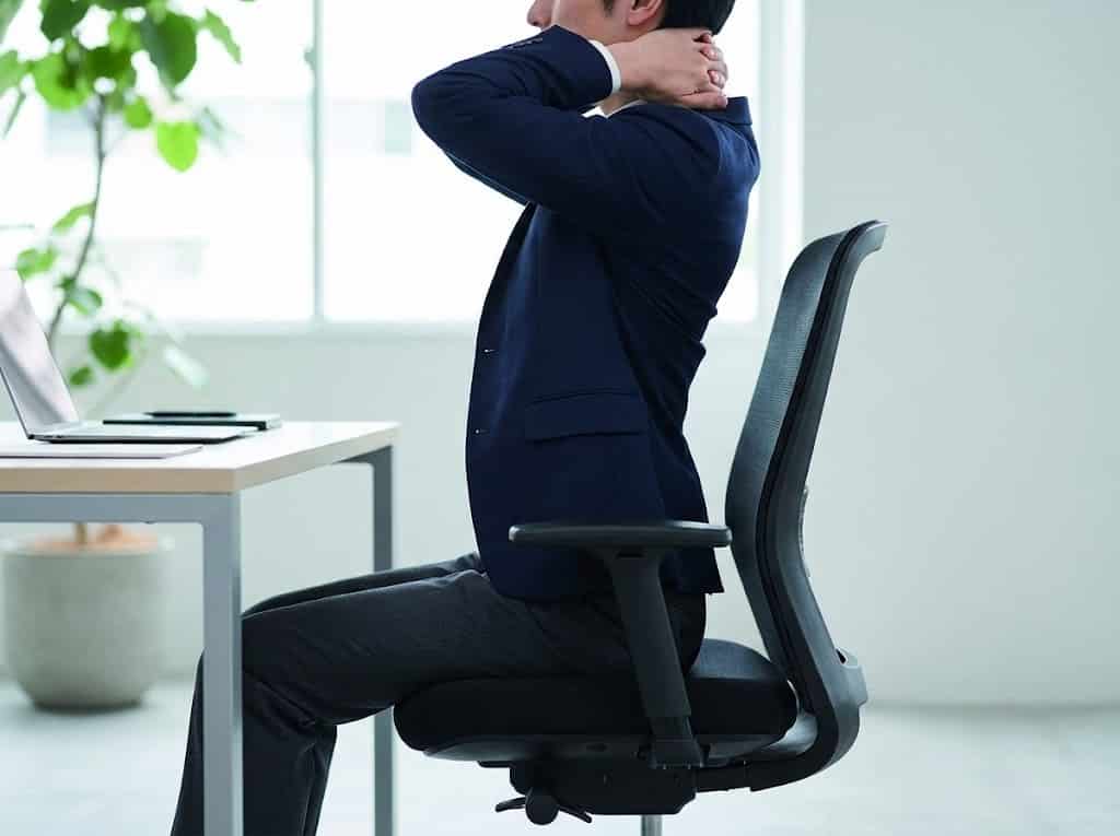Man stretching at office desk